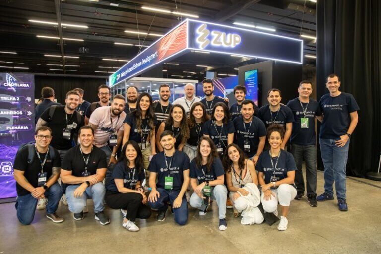 Imagem capa do conteúdo sobre StartSe AI Day 2024, onde há grande parte do time da Zup em uma foto na frente do stand.