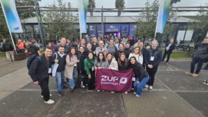 Foto do grupo da Zup Expedition em frente a entrada do World AI Summit 2025.