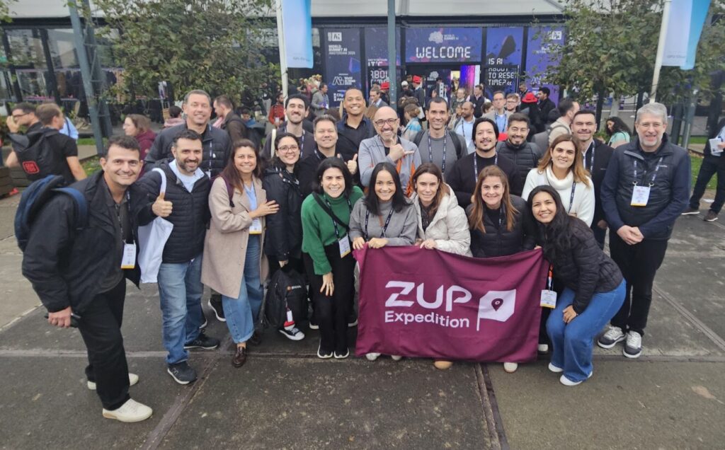 Foto do grupo da Zup Expedition em frente a entrada do World AI Summit 2025.